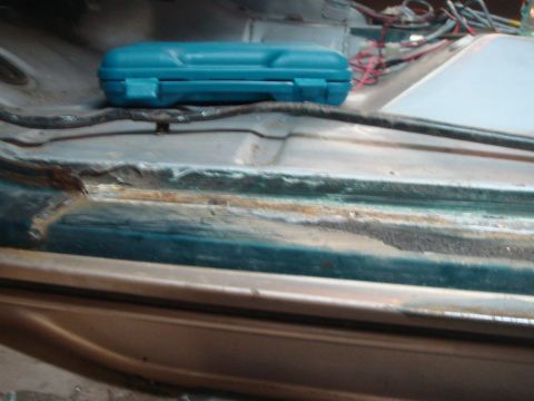 1996 Ford Bronco - The interior door jam of a vehicle shows signs of rust and repair work, with a blue toolbox and wiring visible.