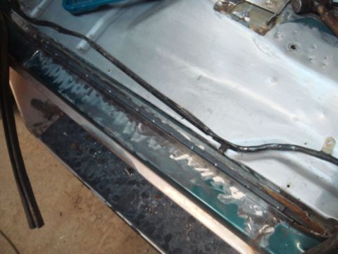 1996 Ford Bronco - This photo shows a section of a vehicle's door jamb undergoing repair, with visible metalwork and some remnants of paint.
