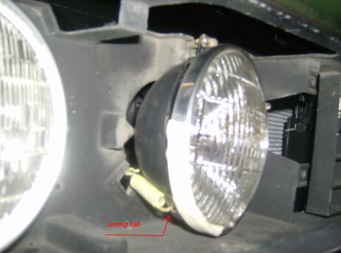 1970 Ford Ranchero - Headlight assembly detail with a visible spring tab, likely from an older vehicle.