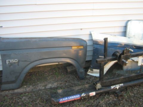 1986 Ford Bronco - Fender and trailer hitch parts are shown, with "F150" visible on the fender and a "DIXIE CHICKEN" sticker on the hitch.