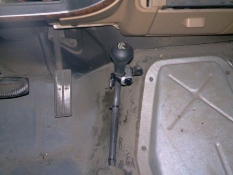 1989 Ford Bronco - Interior view of a vehicle's floor, focusing on the gear shifter and surrounding components.