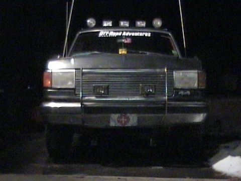 1990 Ford Bronco - A 1990 Ford Bronco is shown from the front, equipped with off-road lights and a sticker on the windshield.