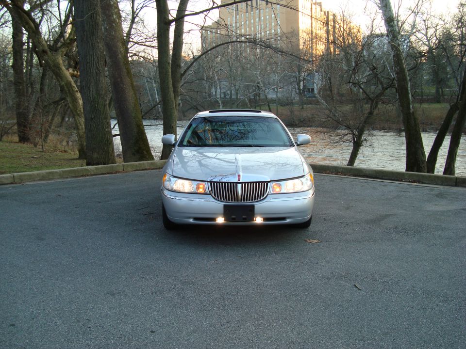 Silver Lincoln Town Car parked outdoors, front view