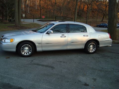 2002 Lincoln Town Car - Side profile of a silver 2002 Lincoln Town Car parked on an asphalt surface.