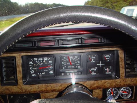 1986 Ford Bronco - Interior view of a 1986 Ford Bronco's dashboard, a woodgrain finish and various gauges including speedometer, tachometer, fuel, oil, temper…