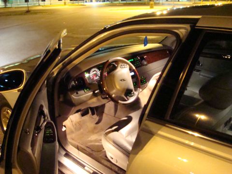 2002 Lincoln Town Car - The interior of a car is shown at night with the driver's side door open.