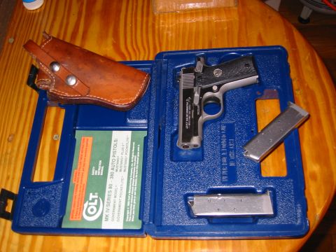 1996 Ford Bronco - Colt Mustang pistol, holster, and extra magazines are neatly arranged in a blue carrying case.