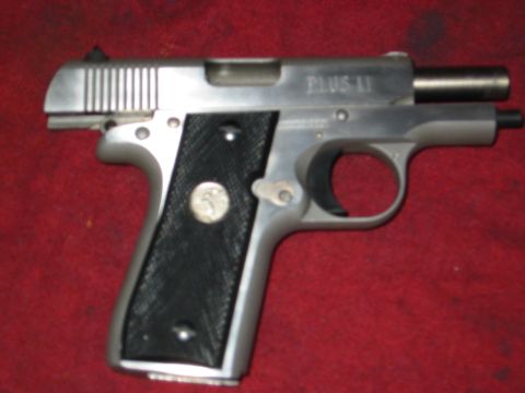 1996 Ford Bronco - A Colt Mustang Plus II pistol is shown against a red fabric surface.
