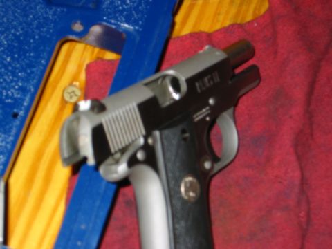1996 Ford Bronco - A close-up view of a pistol, identified by the marking 'PUG II' on its slide.