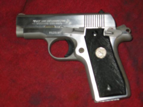 1996 Ford Bronco - A close-up of a Colt Mustang pistol with textured black grips and a silver emblem on the right grip.