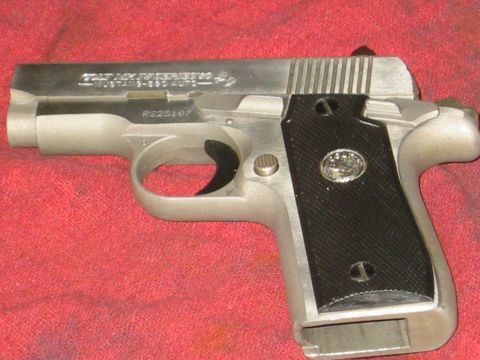 1996 Ford Bronco - A close-up view of a Colt Mustang pistol, identified by its markings and design.