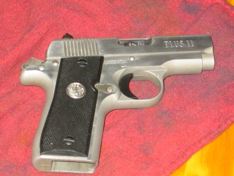 1996 Ford Bronco - A silver semi-automatic pistol with black grips, marked "PLUS 11" and "CAL .380", rests on a red cloth.