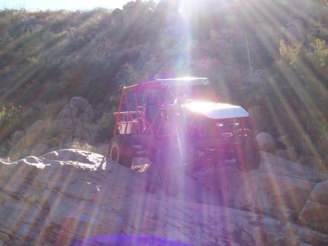 1981 Ford F-150 - A custom off-road buggy navigates a rocky trail under bright sunlight.