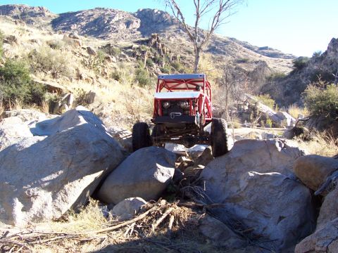 1981 Ford F-150 - A heavily modified off-road vehicle traverses a rocky, mountainous terrain.