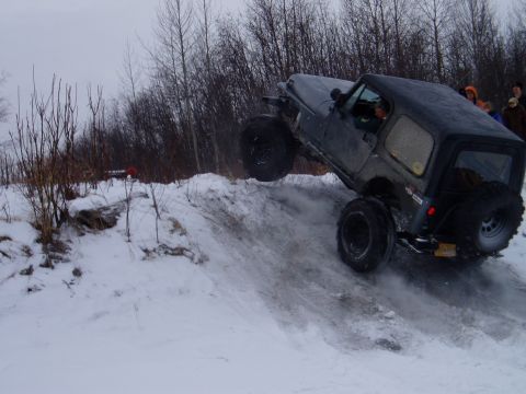 2000 Ford E350 - A Jeep Wrangler navigates a challenging snowy terrain, demonstrating its off-road capabilities.