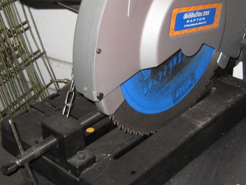 1996 Ford Bronco - Close-up of a metal cutting saw with a chain attached to the vise.