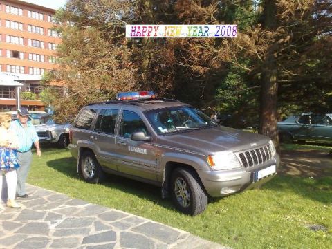 1991 Ford Crown Victoria - A Jeep Grand Cherokee marked "U.S. MARSHAL" is parked outside a building with a light bar on its roof.