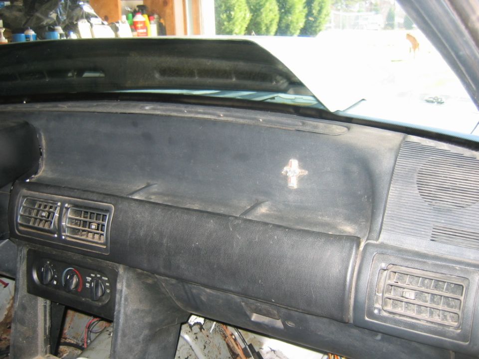 1992 Ford Mustang dashboard showing air vents, climate controls, and a small emblem