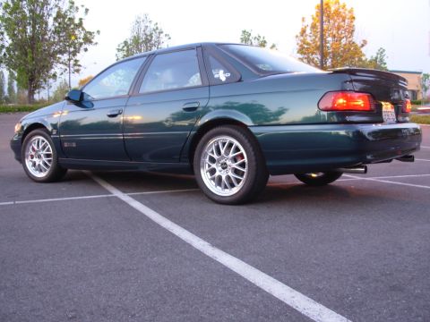 1995 Ford Taurus - The rear view of a dark green 1995 Ford Taurus SHO sedan parked in a lot.