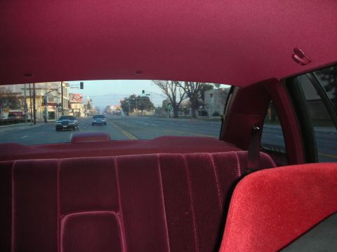 1992 Ford Crown Victoria - Driving down a suburban street with other cars on the road, seen from the back seat.