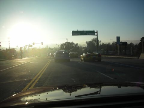 1992 Ford Crown Victoria - A yellow convertible sports car is seen from behind on a highway during a sunny day.