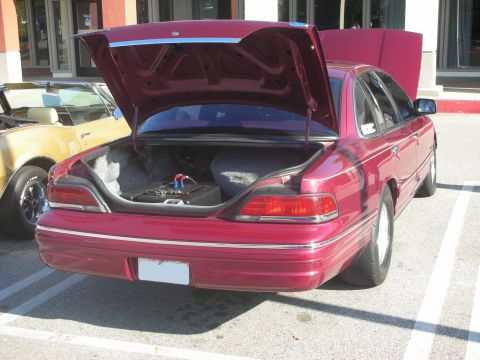 1992 Ford Crown Victoria - Rear view of a red 1992 Ford Crown Victoria at a car meet, with trunk and hood open.