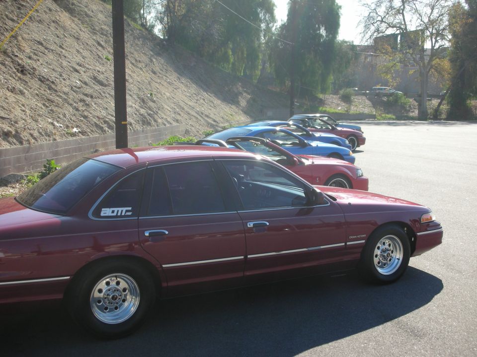 Maroon 1992 Ford Crown Victoria side view with aftermarket wheels and 'BOTT' decal
