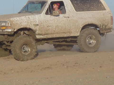 1992 Ford Bronco - This 1992 Ford Bronco is covered in mud as it drives through a watery terrain.