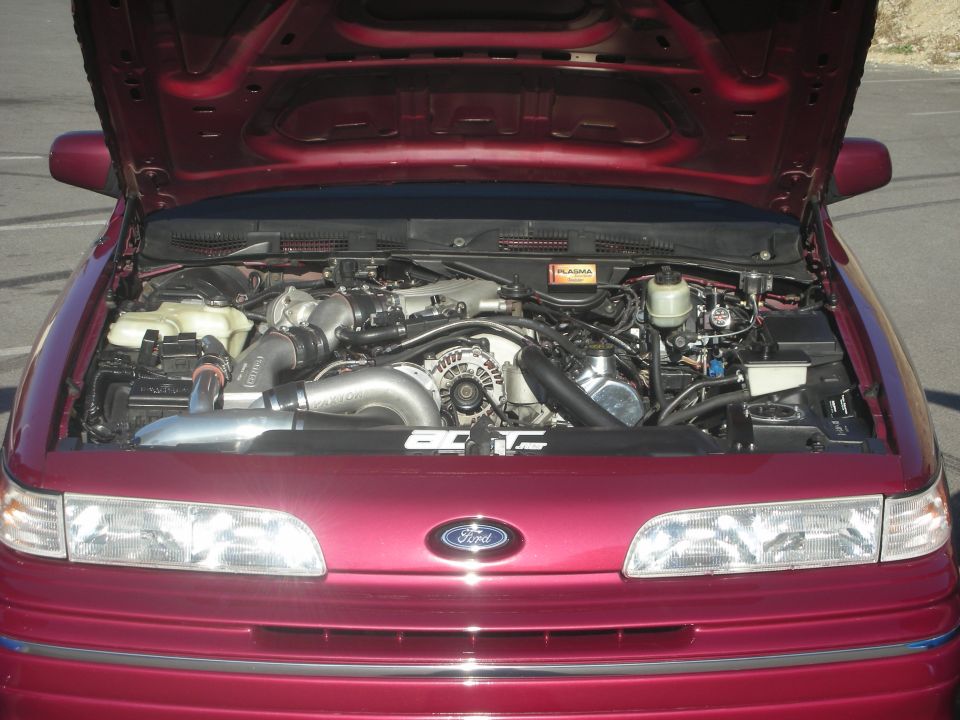 Red 1992 Ford Crown Victoria engine bay with aftermarket turbocharger and intercooler. Hood is open