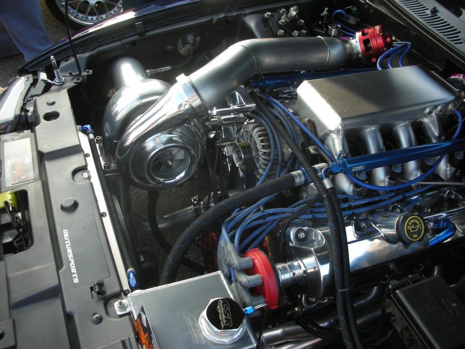 Polished supercharged engine bay with blue plug wires and intake manifold