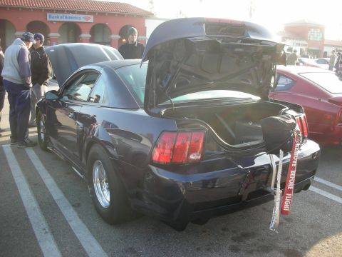 1998 Ford Crown Victoria - Modified Ford Mustang with drag tires and a "Remove Before Flight" tag visible.