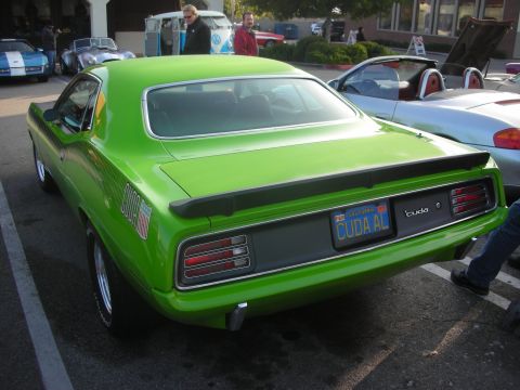 1998 Ford Crown Victoria - Rear view of a bright green Plymouth Barracuda at a car meet, parked next to other vehicles.