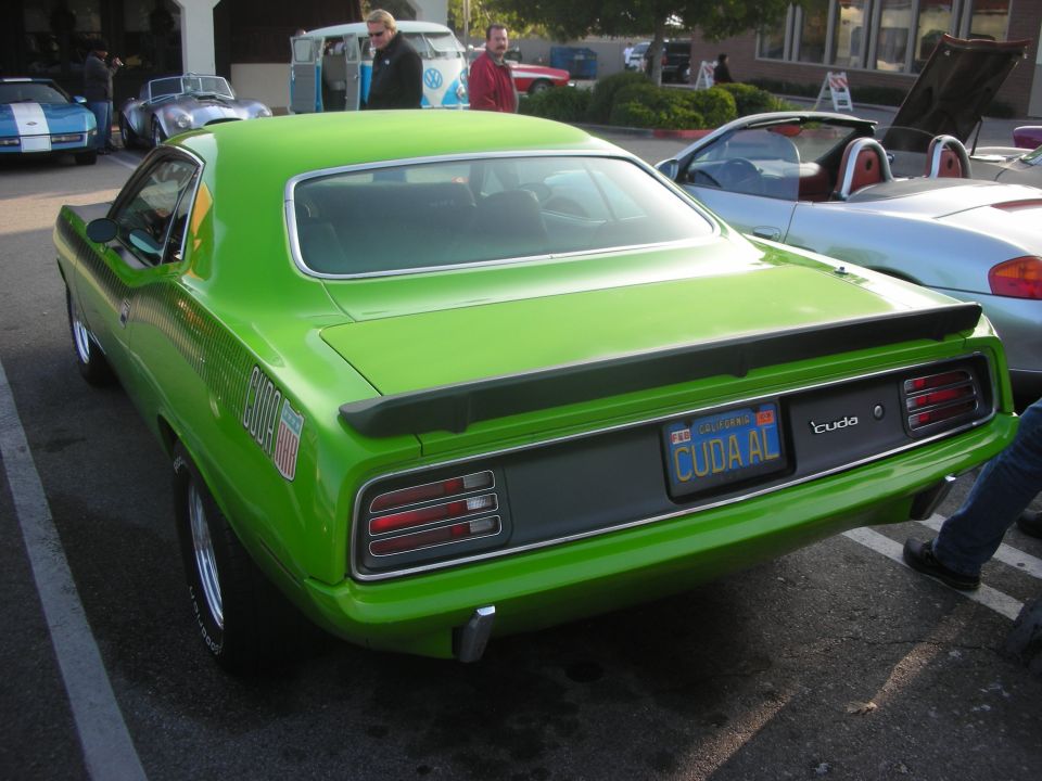 Rear of bright green muscle car with 'CUDA AL' plate at a car show