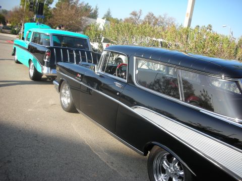 1998 Ford Crown Victoria - Two classic 1956 Chevrolet Nomad station wagons are parked on a street.