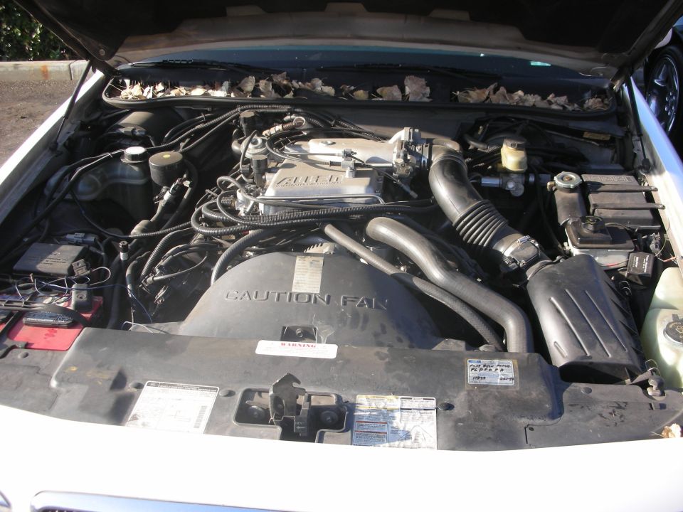Engine bay with 'CAUTION FAN' label and Alpine markings