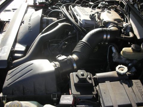 1998 Ford Crown Victoria - Close-up view of a car's engine bay, showing the air intake system and cooling fan.