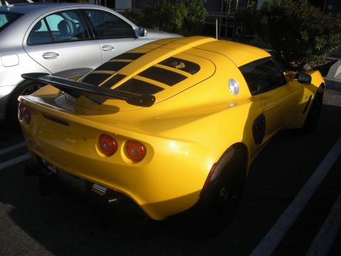 1998 Ford Crown Victoria - Rear view of a yellow Lotus Elise sports car parked in a lot.