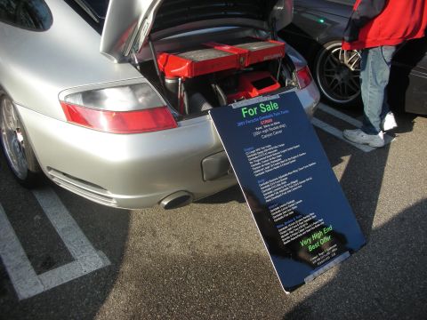 1998 Ford Crown Victoria - Silver Porsche 911 GT2 with 'For Sale' sign detailing its features and price.