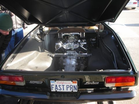 1998 Ford Crown Victoria - The rear of a dark green car shows its exposed V8 engine and transmission.