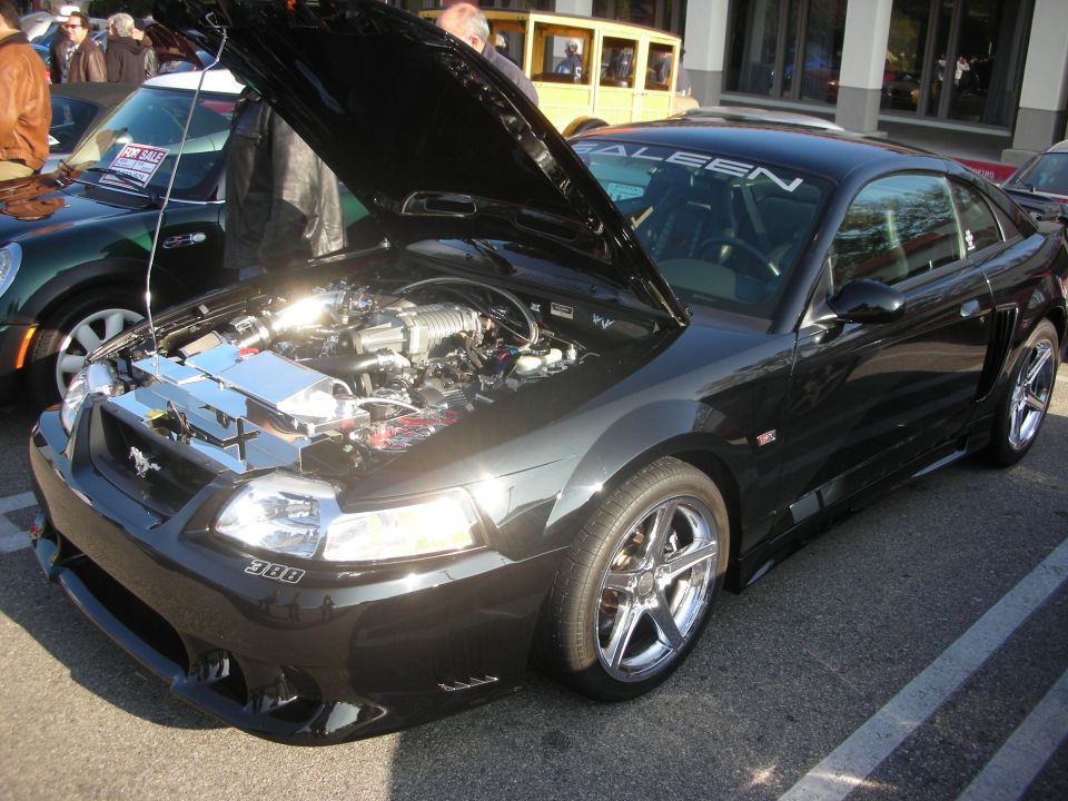 Black Saleen Ford Mustang with hood up showing engine at a car meet