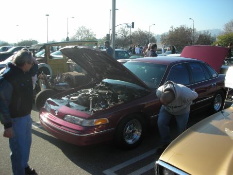 1998 Ford Crown Victoria - A maroon 1998 Ford Crown Victoria is displayed with its hood open at a car meet.