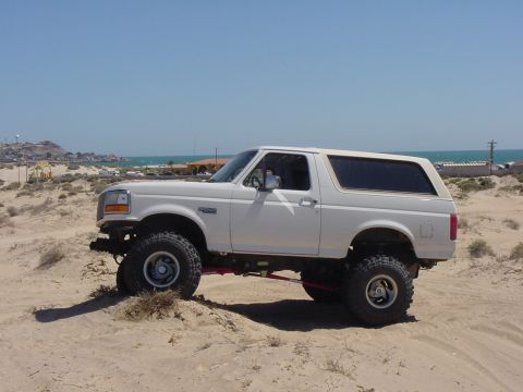 1992 Ford Bronco - This 1992 Ford Bronco is parked on a sandy terrain near the coast.