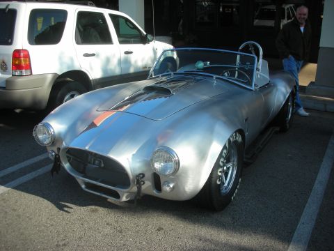 1998 Ford Crown Victoria - A silver Shelby Cobra replica is parked next to a white SUV at a coffee meet.