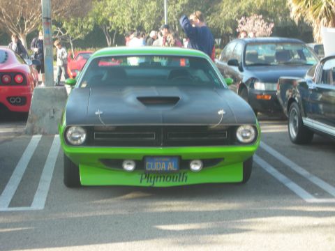 1998 Ford Crown Victoria - A bright green Plymouth Barracuda is parked in a lot with other vehicles.