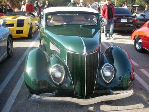 1998 Ford Crown Victoria - A 1939 Ford convertible is parked at a car meet, with other vehicles in the background.