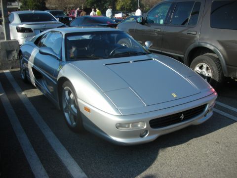 1998 Ford Crown Victoria - Silver Ferrari F355 parked in a lot with other vehicles around.