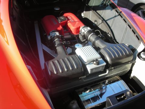 1998 Ford Crown Victoria - The engine bay of a red Ferrari features prominent red intake manifolds and black air filter housings.