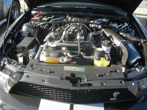 1998 Ford Crown Victoria - The engine bay of a car is shown with various components and a prominent air intake system.