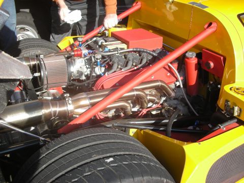 1998 Ford Crown Victoria - Close-up view of a custom engine bay in a yellow race car, showing intricate plumbing and mechanical components.