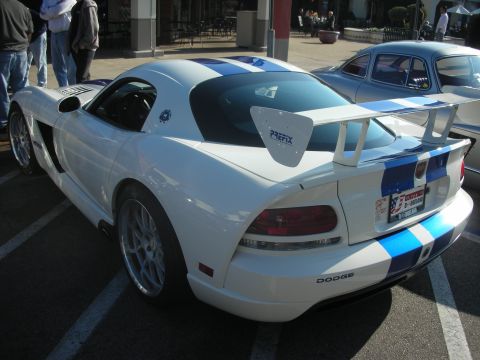 1998 Ford Crown Victoria - Dodge Viper with racing stripes and a prominent rear spoiler parked at an event.